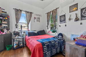 Bedroom with dark wood-style flooring