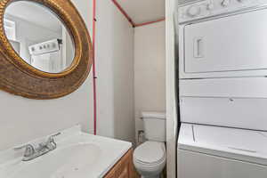 Bathroom with vanity and stacked washing machine and dryer
