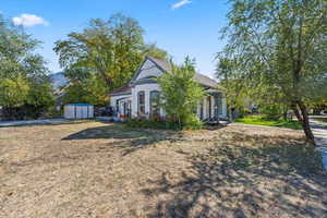 View of front of house with a shed, a front lawn, and stucco siding
