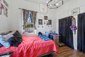 Bedroom with wood finished floors and a chandelier