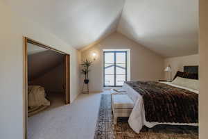 Bedroom featuring carpet floors and vaulted ceiling