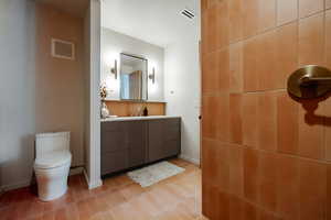 Half bathroom with vanity and toilet