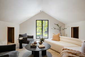 Carpeted living area with vaulted ceiling
