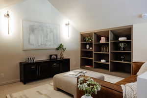 Carpeted living room featuring vaulted ceiling