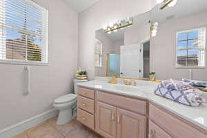 Bathroom with vanity, light tile patterned floors, and a shower stall