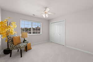Living area featuring carpet flooring and a ceiling fan