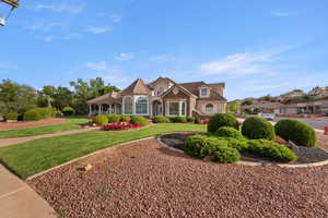 View of front of house featuring a front lawn and stone siding