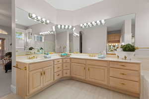 Full bath with double vanity and a shower stall