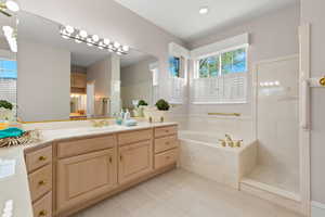 Full bath with vanity, a bath, and a marble finish shower