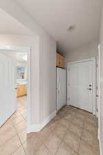 Hall with light tile patterned floors and baseboards