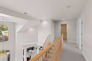 Hall featuring an upstairs landing, carpet, and recessed lighting