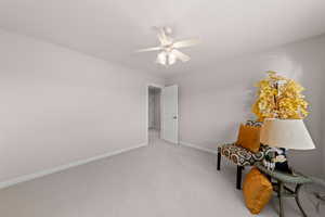 Living area with carpet floors and a ceiling fan