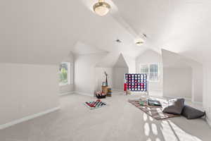 Game room with carpet floors, plenty of natural light, and vaulted ceiling