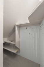 Mudroom featuring carpet flooring and vaulted ceiling