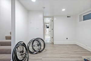 Below grade area with light wood-type flooring, recessed lighting, and electric panel