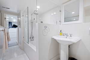 Full bath with a walk in shower and tile patterned flooring