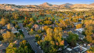 Aerial view of property and surrounding area with mountains and nearby suburban area