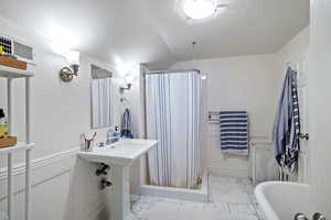 Bathroom featuring a shower stall, a freestanding bath, and light tile patterned floors