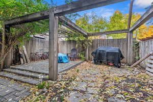 Fenced backyard featuring area for grilling, a pergola, and a patio