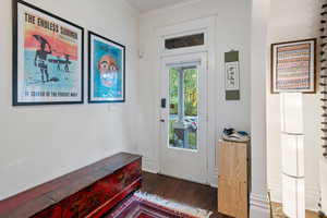 Doorway featuring wood finished floors and ornamental molding