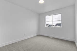Spare room with light colored carpet and baseboards