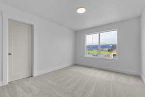 Spare room with light carpet and a mountain view