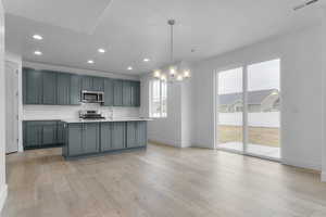 Kitchen featuring a kitchen island with sink, backsplash, hanging light fixtures, recessed lighting, and appliances with stainless steel finishes