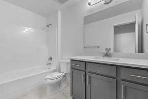 Full bathroom featuring vanity, washtub / shower combination, and light marble finish flooring