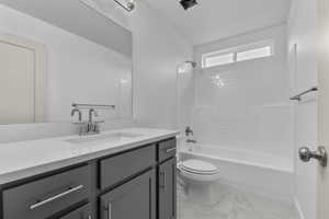 Bathroom with tub / shower combination, vanity, and light marble finish flooring