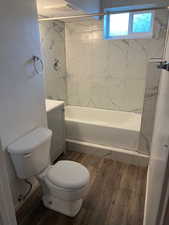 Bathroom with vanity, wood finished floors, and shower / tub combination
