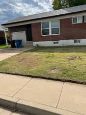 Ranch-style house with a front yard, brick siding, concrete driveway, and entry steps