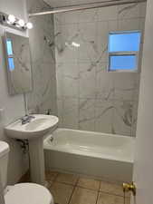 Full bath featuring shower / bathtub combination and light tile patterned flooring