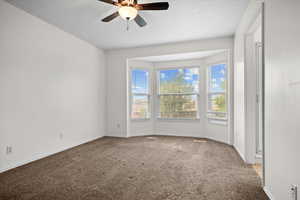Spare room with light colored carpet and a ceiling fan