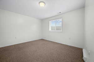 Unfurnished room featuring carpet floors and a textured ceiling