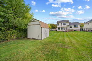 Fenced backyard featuring a storage shed