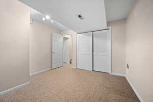 Unfurnished bedroom with light carpet and a closet