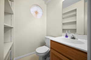 Half bathroom featuring vanity and toilet