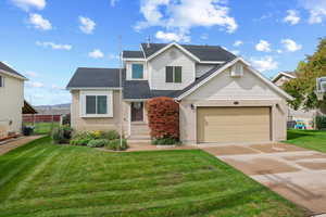 Traditional home with concrete driveway, brick siding, roof with shingles, and an attached garage