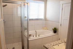 Full bathroom with a shower stall, a bath, and vanity