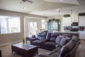 Living room featuring ceiling fan, recessed lighting, lofted ceiling, and dark carpet