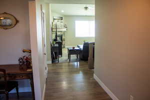Corridor featuring dark wood-style flooring and a desk