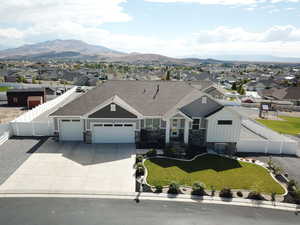 Craftsman house with concrete driveway, board and batten siding, an attached garage, a residential view, and stone siding