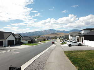 View of asphalt street with a mountain view, sidewalks, and a residential view