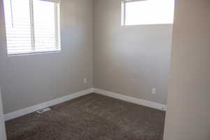 Spare room featuring carpet floors and baseboards