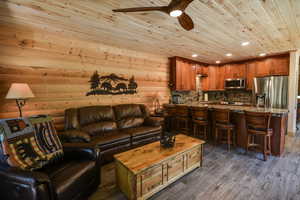 Living room featuring wood ceiling, recessed lighting, dark wood finished floors, and ceiling fan