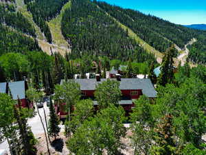 Aerial view of property and surrounding area featuring a forest