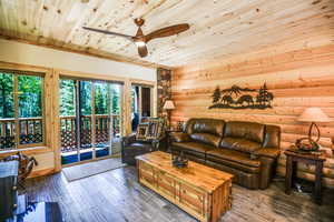 Living room with hardwood / wood-style floors, a ceiling fan, and wooden ceiling