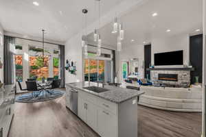 Kitchen featuring pendant lighting, white cabinets, light stone countertops, recessed lighting, and light wood finished floors