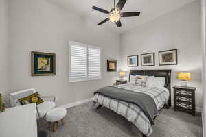 Carpeted bedroom with baseboards and a ceiling fan