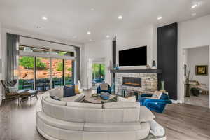 Living area featuring recessed lighting, a fireplace, and wood finished floors